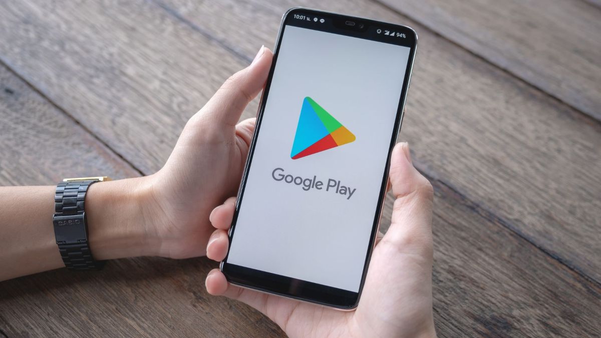 Person hält ein Handy mit dem Loge des Google Play Store in den Händen.